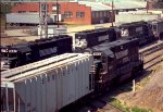 NS 4163 shoves cars while a string of SD's pulls a grain train out of the siding